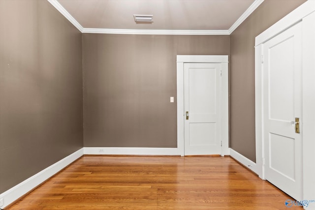 empty room featuring crown molding and hardwood / wood-style floors