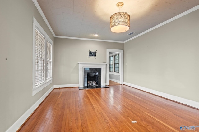 unfurnished living room featuring hardwood / wood-style floors and crown molding