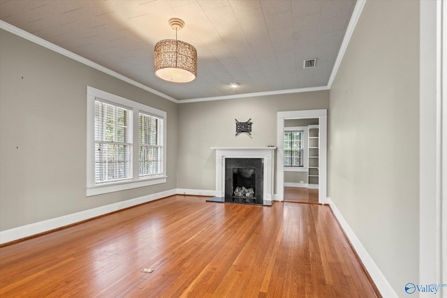 unfurnished living room with plenty of natural light, hardwood / wood-style floors, and ornamental molding