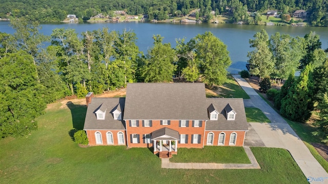 birds eye view of property with a water view and a wooded view