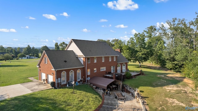 view of front of house with a garage, brick siding, concrete driveway, a chimney, and a front yard