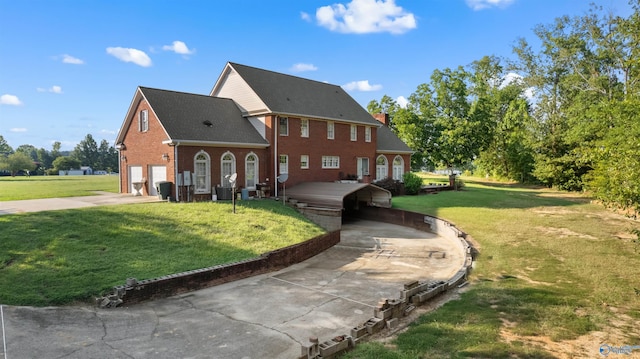 view of front of house with brick siding, a chimney, central air condition unit, a garage, and a front lawn