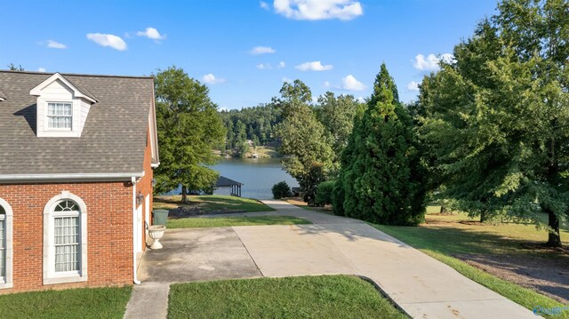 exterior space with a water view and concrete driveway