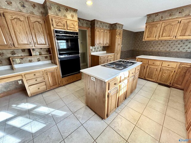 kitchen with stainless steel gas stovetop, sink, light tile patterned flooring, a kitchen island, and a textured ceiling