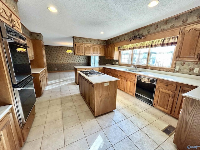 kitchen with a textured ceiling, a sink, dishwasher, stovetop with downdraft, and wallpapered walls