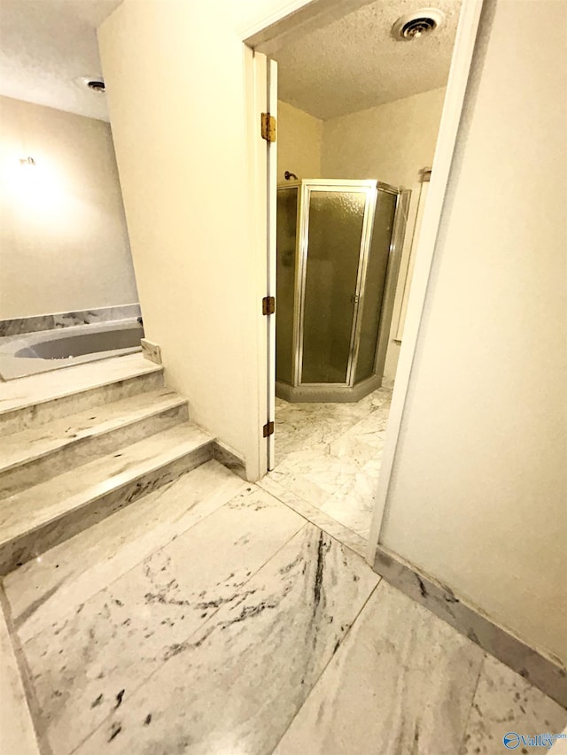 interior space with marble finish floor, visible vents, and a textured ceiling