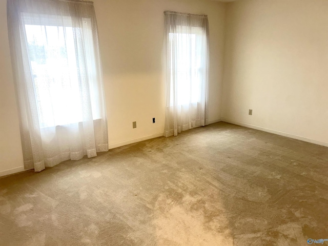 carpeted spare room featuring baseboards