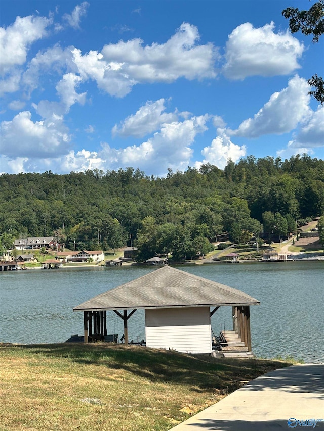 view of dock featuring a water view and a lawn