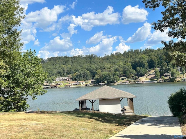 dock area with a lawn and a water view