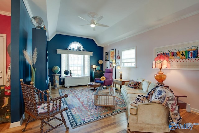 living room with hardwood / wood-style floors, vaulted ceiling, ceiling fan, and crown molding