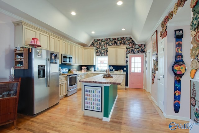 kitchen featuring wooden counters, light wood-type flooring, stainless steel appliances, vaulted ceiling, and cream cabinets