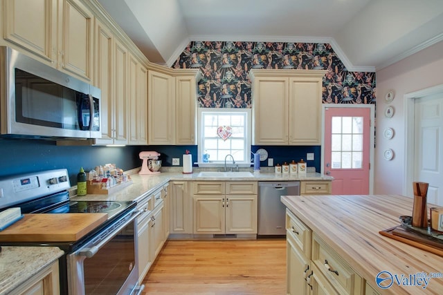 kitchen featuring crown molding, sink, stainless steel appliances, and vaulted ceiling