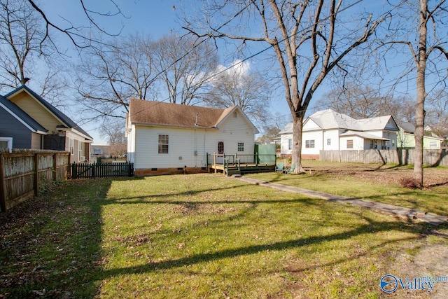 back of house featuring a yard and a wooden deck