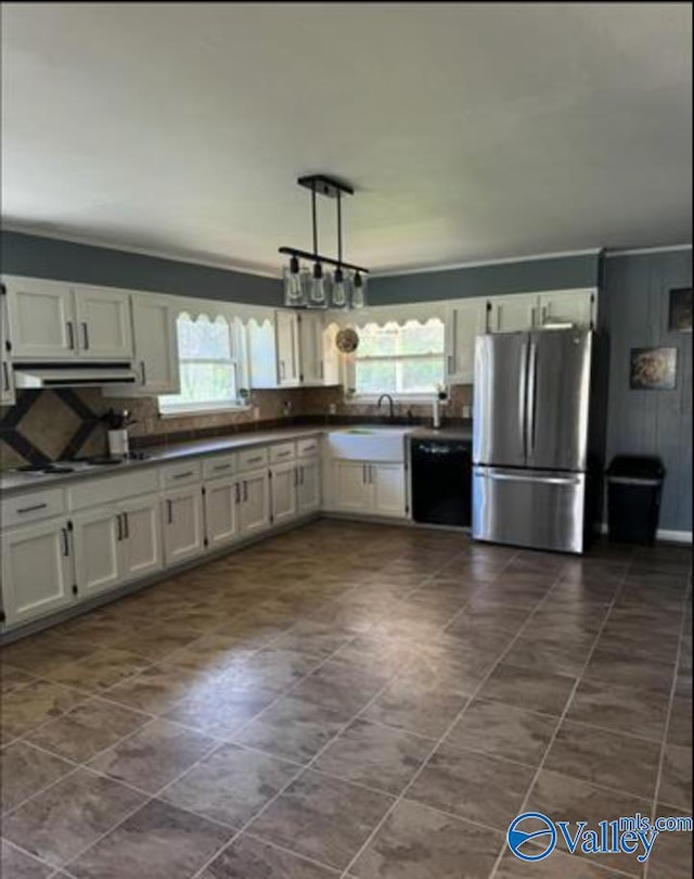 kitchen featuring stainless steel refrigerator, white cabinetry, black dishwasher, and a wealth of natural light