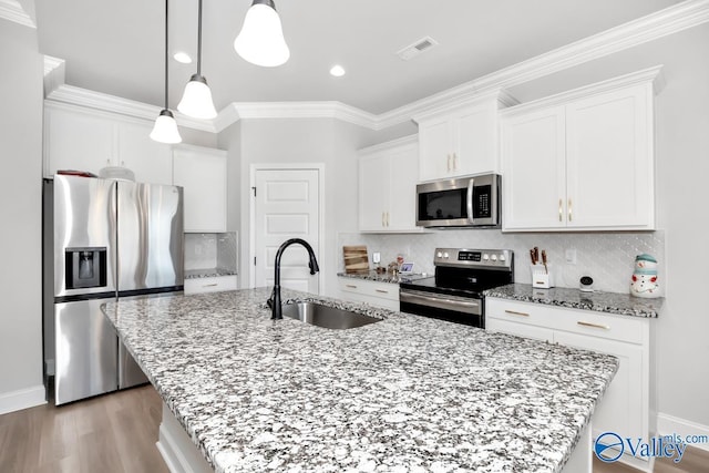 kitchen featuring white cabinetry, sink, stainless steel appliances, and a center island with sink