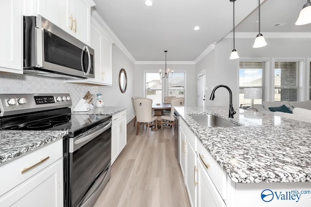 kitchen with light stone counters, sink, white cabinetry, and stainless steel appliances