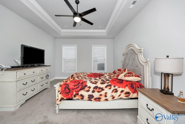 bedroom with ceiling fan, crown molding, light carpet, and a tray ceiling