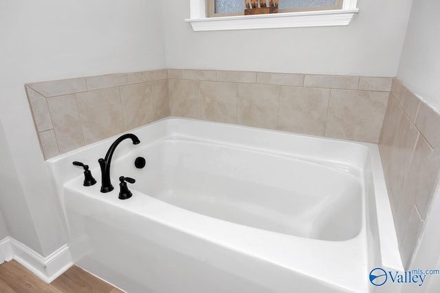 bathroom featuring a tub to relax in, plenty of natural light, and wood-type flooring