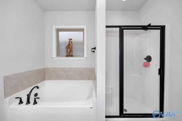 bathroom featuring shower with separate bathtub