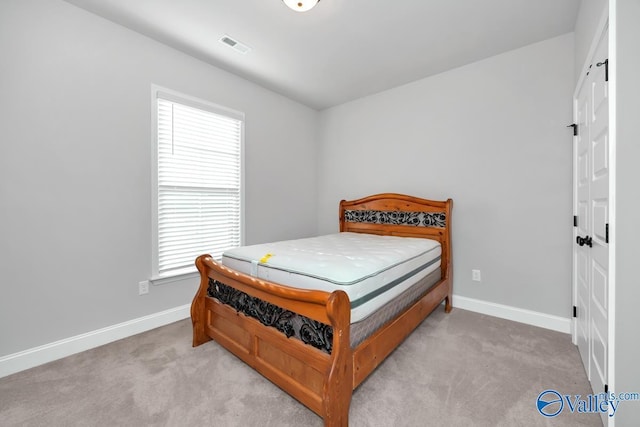 bedroom with light carpet and multiple windows