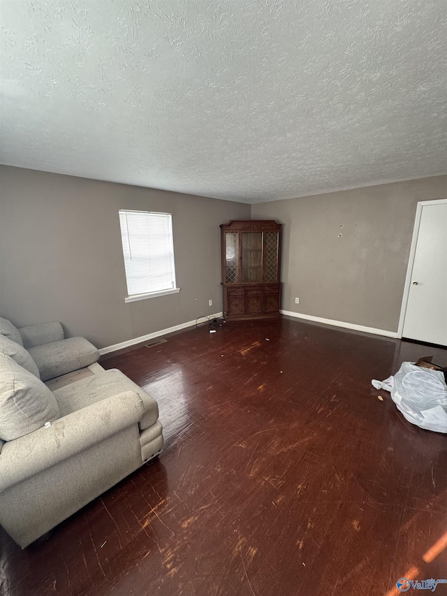 living room with dark wood-type flooring and a textured ceiling