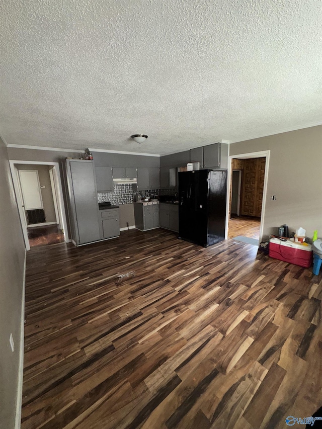 unfurnished living room with ornamental molding, dark hardwood / wood-style floors, and a textured ceiling