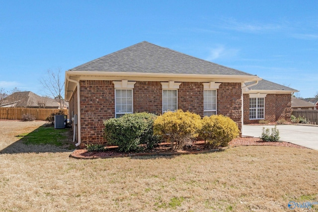 exterior space with cooling unit, a front yard, and fence