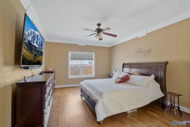 bedroom with ceiling fan, light wood-style flooring, baseboards, and ornamental molding