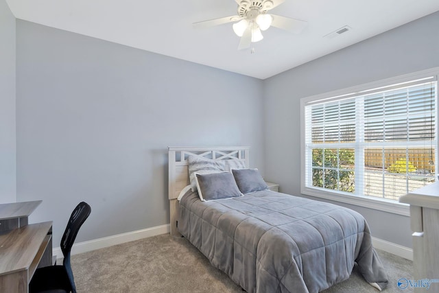 carpeted bedroom featuring visible vents, baseboards, and a ceiling fan