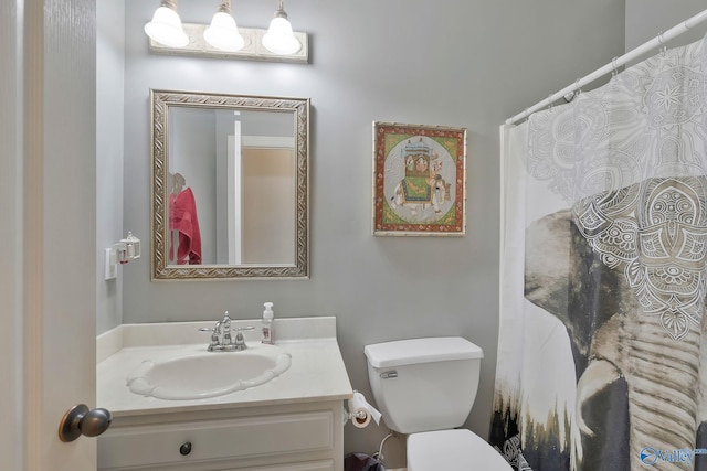 full bathroom featuring a shower with shower curtain, toilet, and vanity