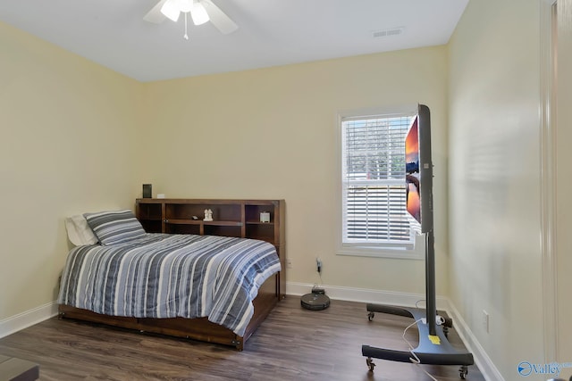 bedroom with visible vents, baseboards, wood finished floors, and a ceiling fan