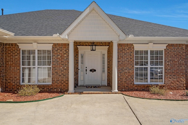 property entrance with brick siding and a shingled roof