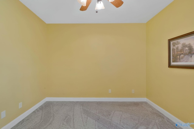 carpeted spare room with a ceiling fan and baseboards