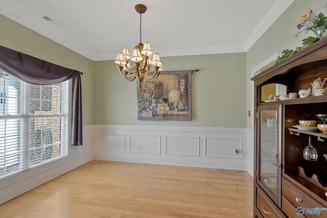 dining space featuring visible vents, a chandelier, crown molding, and light wood finished floors