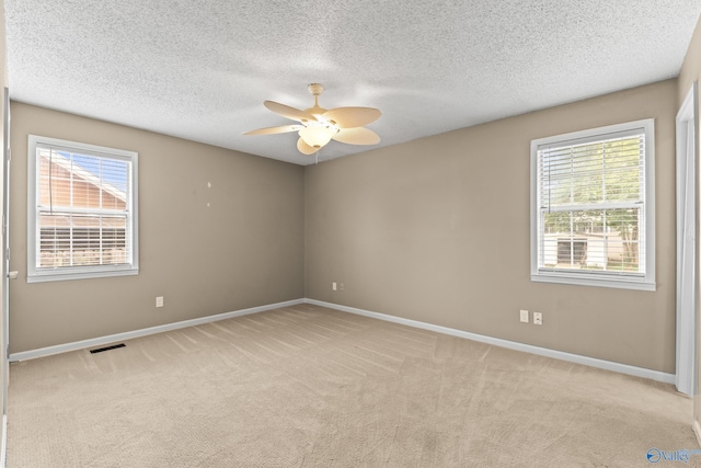 2009 SW Danbury Cir SW, Huntsville, AL 35803 - spare room with healthy amount of natural light, a ceiling fan, light colored carpet, baseboards, and a textured ceiling