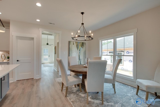 dining area featuring light wood-type flooring and a chandelier