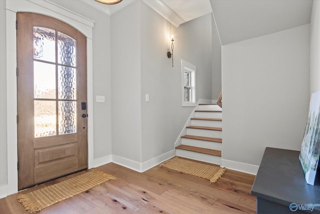 foyer entrance with hardwood / wood-style flooring and ornamental molding