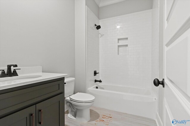 full bathroom featuring tiled shower / bath, vanity, and toilet