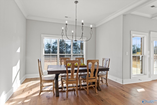 dining room featuring ornamental molding, hardwood / wood-style floors, and a notable chandelier