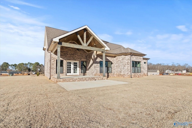 rear view of property featuring a patio area, french doors, and a lawn