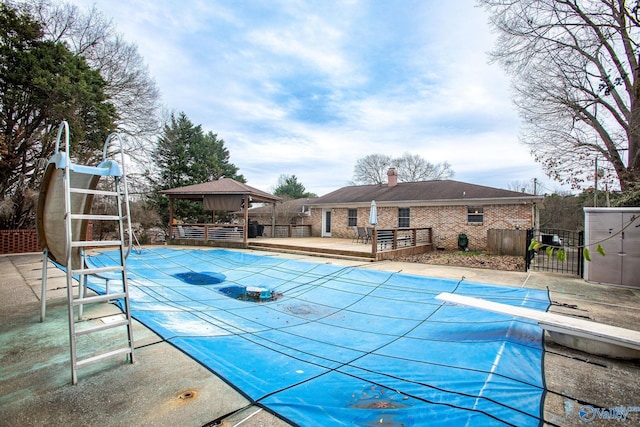 view of pool with a gazebo and a diving board