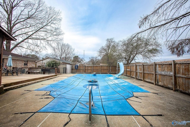 view of pool featuring a water slide and a deck