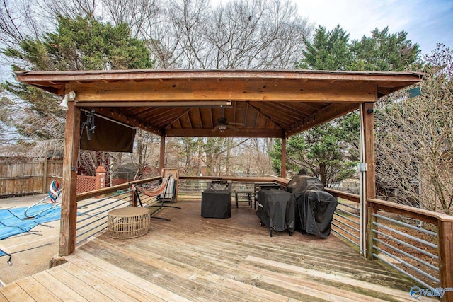 wooden terrace with a gazebo, ceiling fan, and area for grilling