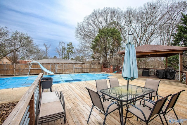 view of pool featuring a grill, a gazebo, a deck, and a water slide