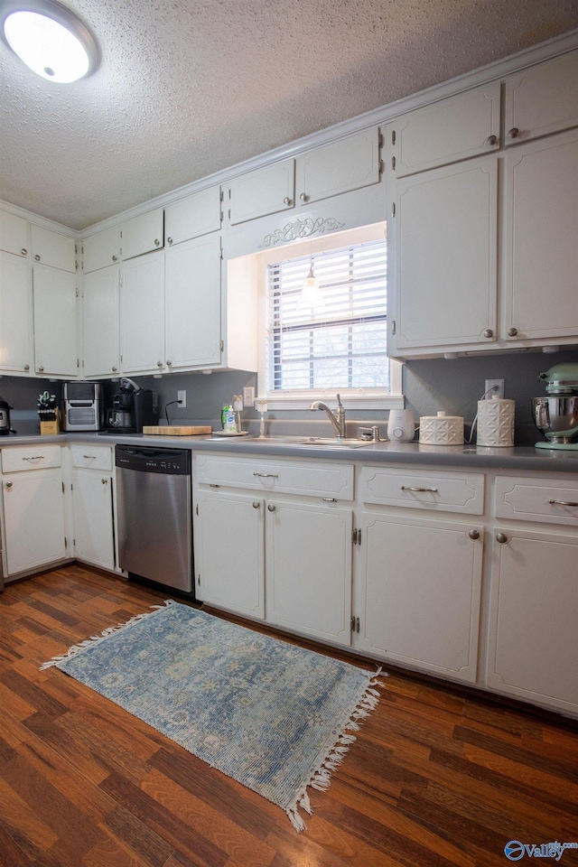 kitchen featuring dark wood-type flooring, stainless steel dishwasher, and white cabinets