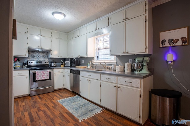 kitchen with sink, dark wood-type flooring, appliances with stainless steel finishes, a textured ceiling, and white cabinets