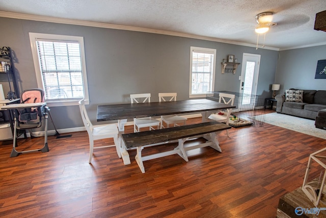 dining space featuring ornamental molding, dark wood-type flooring, a wealth of natural light, and a textured ceiling