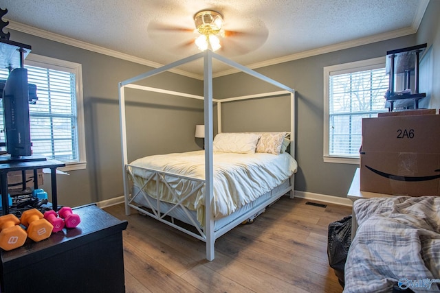 bedroom with multiple windows, hardwood / wood-style floors, and crown molding