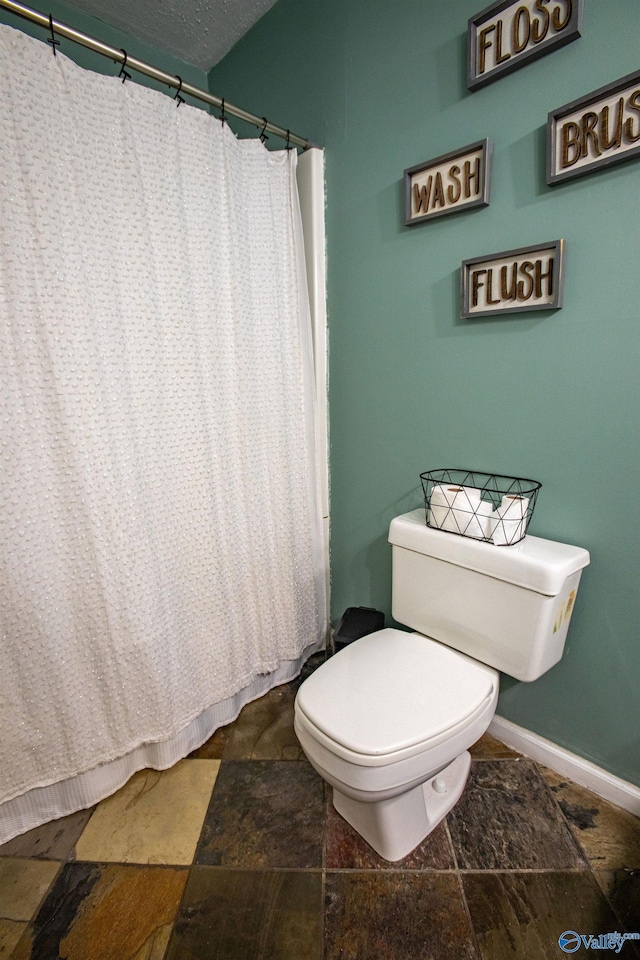 bathroom featuring a textured ceiling and toilet