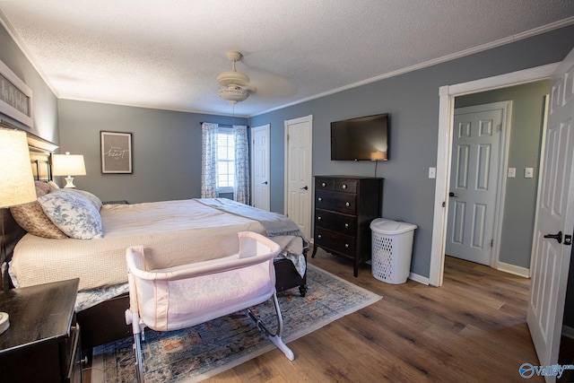 bedroom with hardwood / wood-style floors, crown molding, a textured ceiling, and ceiling fan